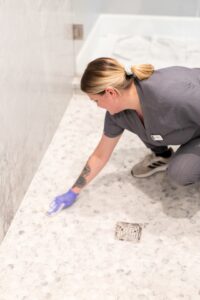 Vella professional scrubbing grime from bathroom tiles during a deep cleaning service in a Dallas home.