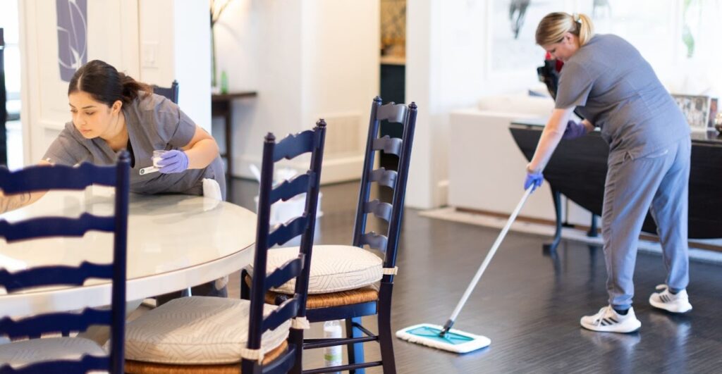 Two professional cleaners working in a home, demonstrating the quality of residential cleaning services near you.