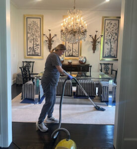Vella cleaner blotting fresh coffee stain on light beige carpet in a Dallas living room using eco-friendly supplies.