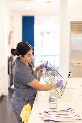 A Vella cleaning professional removes the grease from a stainless steel utensil using eco-friendly products.